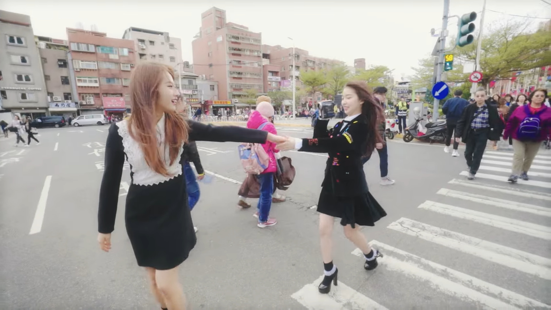 Haseul offering her hand to Yeojin, who is holding the camcorder.